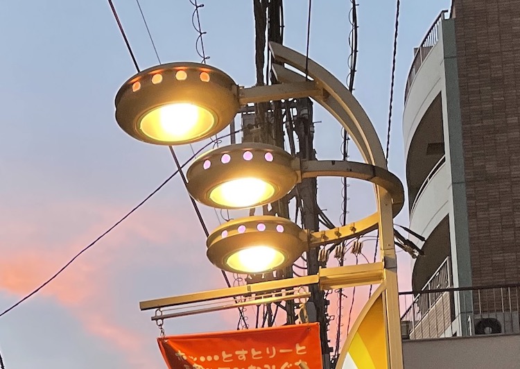 UFOの形をした街灯。一つの街灯に3つのUFOが付いていて、内部が光っている。