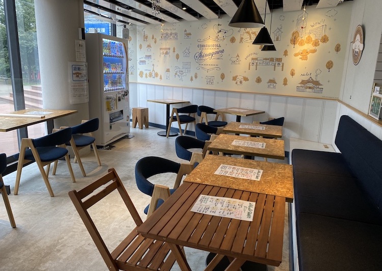 「info＆cafe SQUARE」内観。木製のテーブルがあり、ソファ、布ばりの椅子、木製の椅子が置かれている。写真左には窓を向いたカウンター席が並んでいる